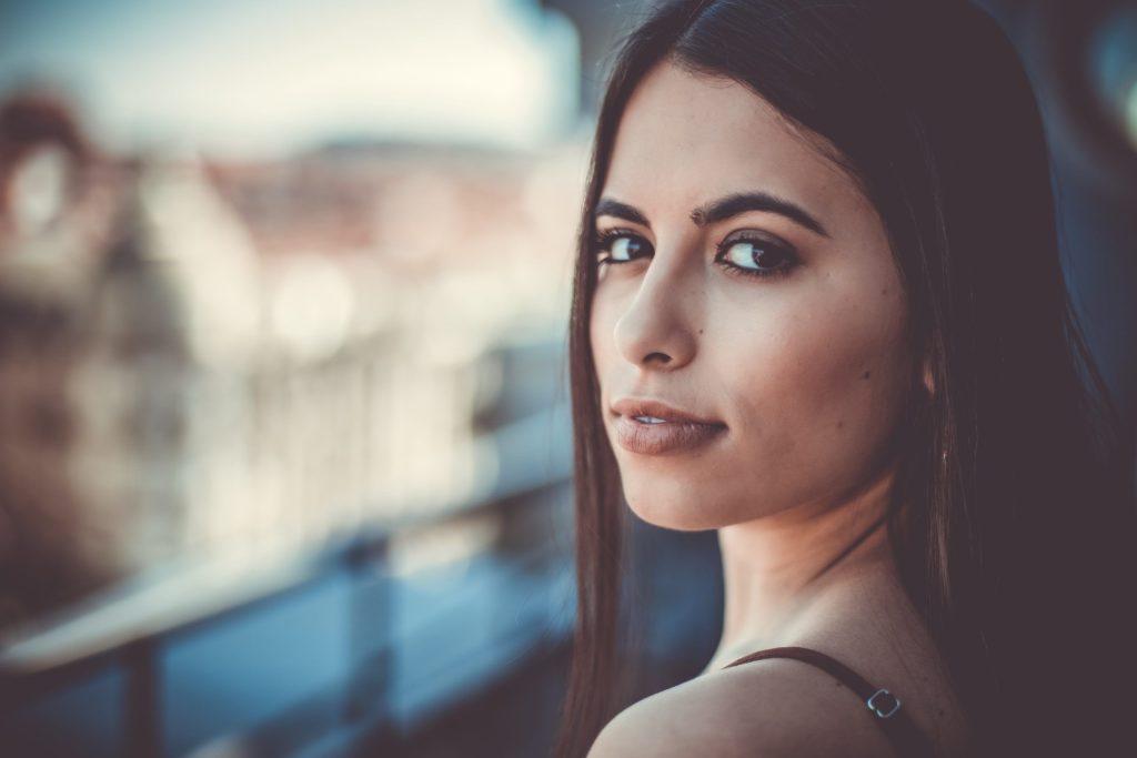Portrait d’une jeune femme au regard intense, la ville de Porto en arrière-plan.