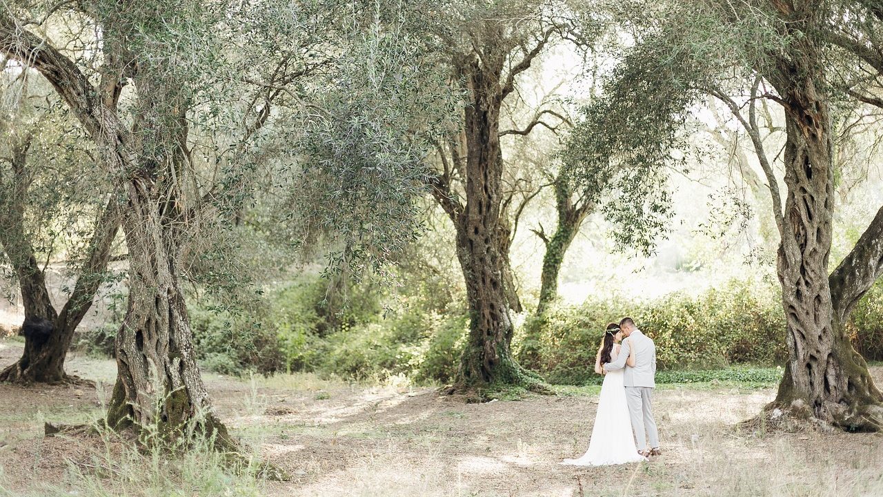 Jeune couple de marié enlacé dans leurs habits de mariage dans une forêt.
