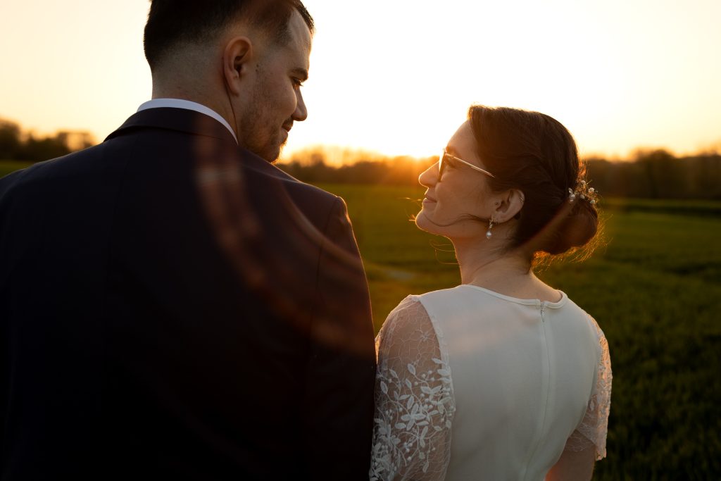 couple de mariés se regardant au coucher du soleil lors d’une séance photo réalisée par un photographe de mariage