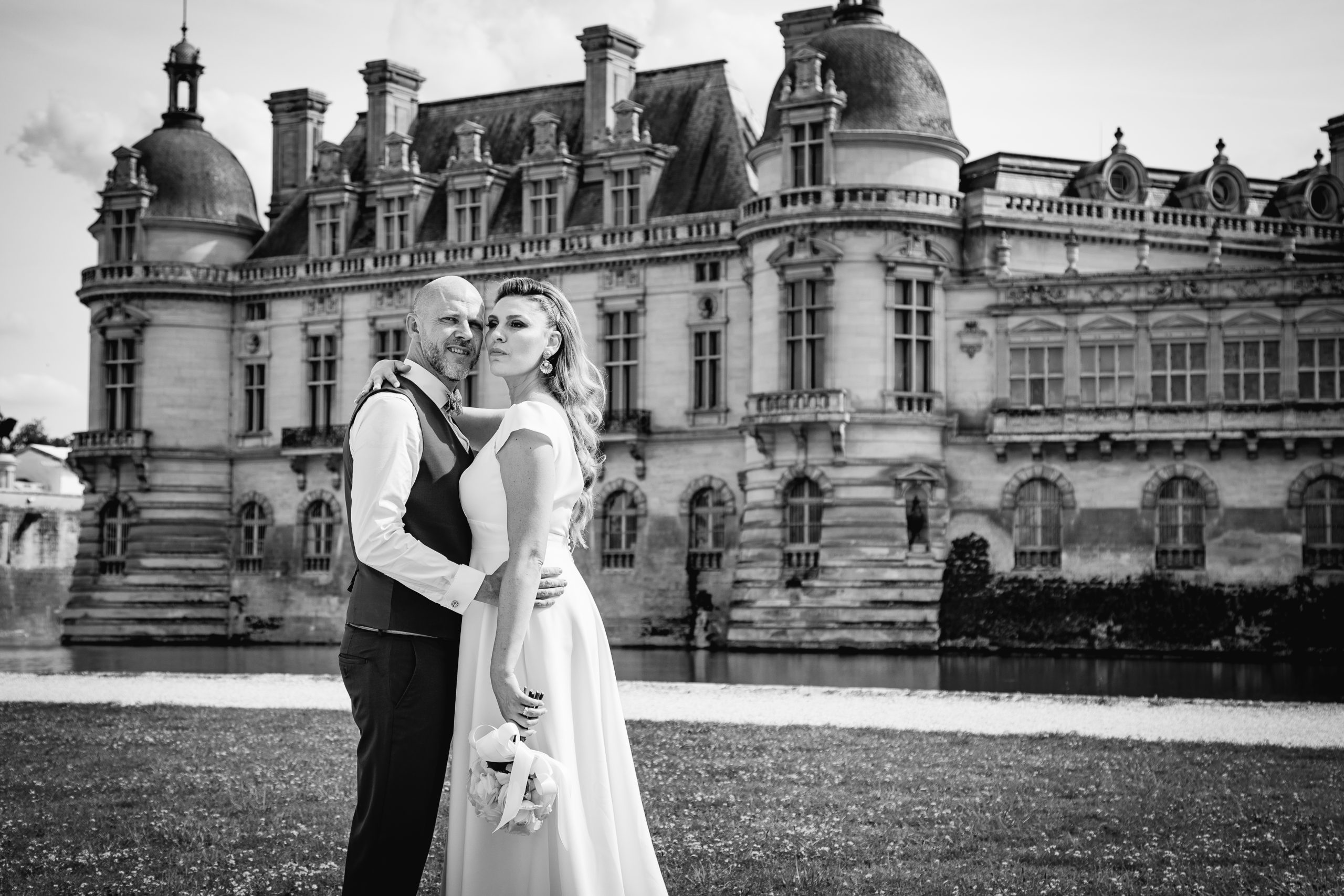 Couple de mariés devant le Château de Chantilly en noir et blanc